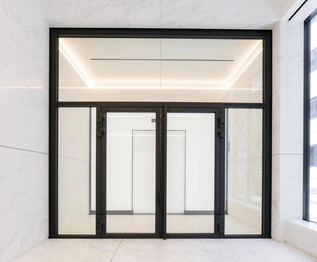 Двупольная противопожарная дверь со стеклом в черном металлическом каркасе для общественных зданий